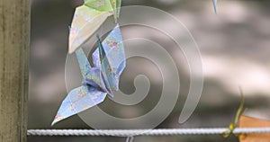 A paper crane swaying in the wind at the traditional street close up handheld