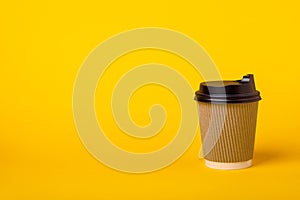 Paper cup of coffee on orange background copy space