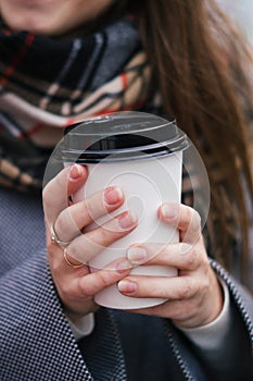 A paper cup of coffee or tean in the hands