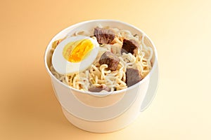 Paper cup with instant ramen noodles with beef and vegetables