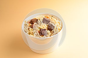 Paper cup with instant ramen noodles with beef and vegetables