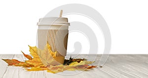 Paper cup take away mug and autumn leaves on white wood