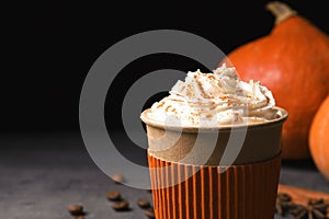 Paper cup of tasty pumpkin spice latte on gray table