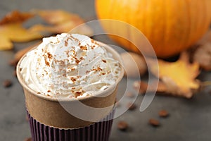 Paper cup with tasty pumpkin spice latte on grey table
