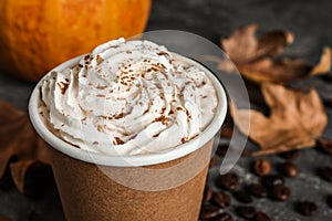 Paper cup with tasty pumpkin spice latte on grey table