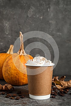Paper cup with tasty pumpkin spice latte on table