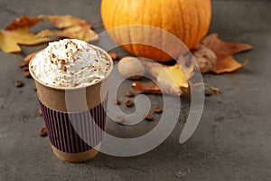 Paper cup with tasty pumpkin spice latte on table. Space for text