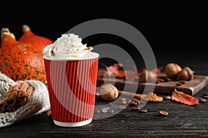 Paper cup with tasty pumpkin spice latte on wooden table. Space for text