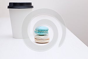 Paper cup whith macaroons on the white table