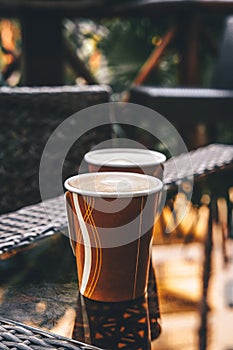 Paper cups with coffee in an outdoor cafe