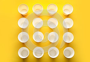 Paper cups on color background, top view.