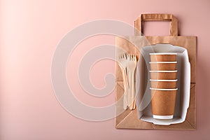 Paper cups, dishes, bag, wooden forks, drinking straws, fast food containers, wooden cutlery on pink background. Eco craft paper t
