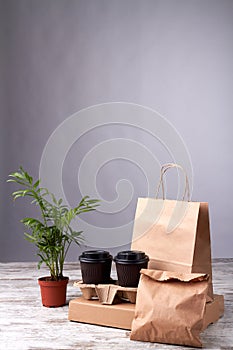 Paper cups and eko packages on wooden floor.