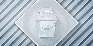 Paper cut Bucket with soap suds icon isolated on grey background. Bowl with water. Washing clothes, cleaning equipment