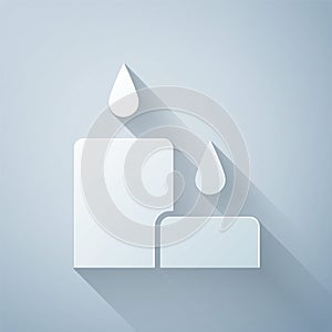 Paper cut Burning candle icon isolated on grey background. Cylindrical candle stick with burning flame. Paper art style