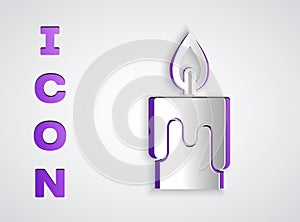 Paper cut Burning candle icon isolated on grey background. Cylindrical candle stick with burning flame. Paper art style