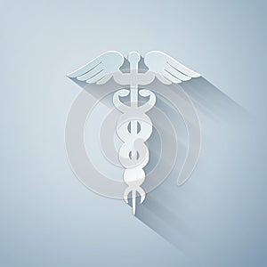 Paper cut Caduceus medical symbol icon isolated on grey background. Medicine and health care concept. Emblem for
