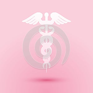 Paper cut Caduceus medical symbol icon isolated on pink background. Medicine and health care concept. Emblem for