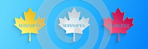 Paper cut Canadian maple leaf with city name Winnipeg icon isolated on blue background. Paper art style. Vector