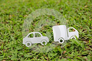 Paper cut of car and truck on green grass background