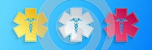 Paper cut Emergency star - medical symbol Caduceus snake with stick icon isolated on blue background. Star of Life