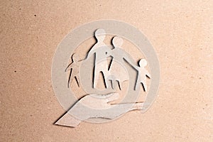 Paper cut family silhouette in a cardboard hand