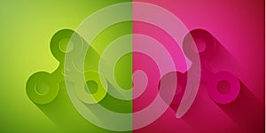 Paper cut Fidget spinner icon isolated on green and pink background. Stress relieving toy. Trendy hand spinner. Paper