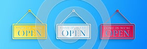 Paper cut Hanging sign with text Come in we`re open icon isolated on blue background. Business theme for cafe or