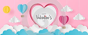 Paper cut of Happy Valentine`s Day text on white heart with heart hot air balloons, sun and cloud on light pink background for