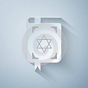 Paper cut Jewish torah book icon isolated on grey background. The Book of the Pentateuch of Moses. On the cover of the photo