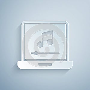 Paper cut Laptop with music note symbol on screen icon isolated on grey background. Paper art style. Vector