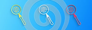 Paper cut Magnifying glass with globe icon isolated on blue background. Analyzing the world. Global search sign. Paper