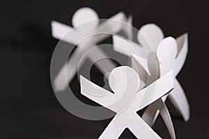Paper cut into people hold their hands connected