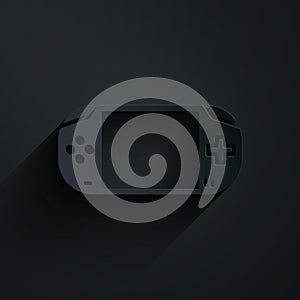 Paper cut Portable video game console icon isolated on black background. Gamepad sign. Gaming concept. Paper art style