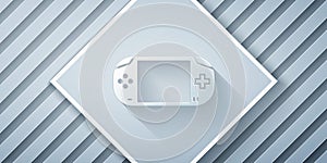 Paper cut Portable video game console icon isolated on grey background. Gamepad sign. Gaming concept. Paper art style