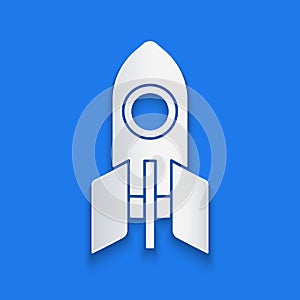 Paper cut Rocket ship icon isolated on blue background. Space travel. Paper art style. Vector