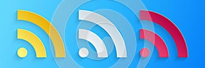 Paper cut RSS icon isolated on blue background. Radio signal. RSS feed symbol. Paper art style. Vector