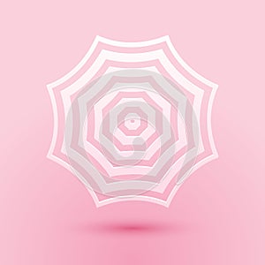Paper cut Sun protective umbrella fo beach icon isolated on pink background. Large parasol for outdoor space. Summer