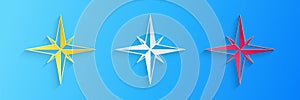 Paper cut Wind rose icon isolated on blue background. Compass icon for travel. Navigation design. Paper art style
