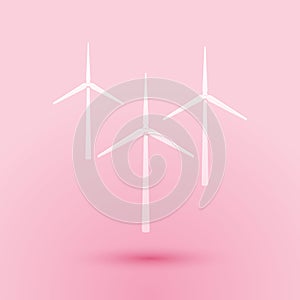 Paper cut Wind turbine icon isolated on pink background. Wind generator sign. Windmill silhouette. Windmills for