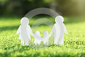 Paper cutout of family on fresh grass. Life insurance