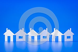 A paper cutout row of houses blue background