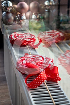 Paper decorative Red & White Lolli Pops with ribbons and christmas balls and reflection in the glass.