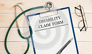 Paper with Disability Claim Form on a table, stethoscope and glasses