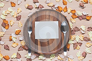 Paper on dish with maple leaves on wood background