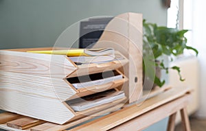Paper and document wooden tray holders and organisers on desk, natural decor concept.