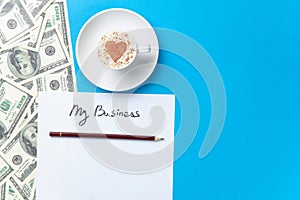 Paper, dollars and cup lying on the table