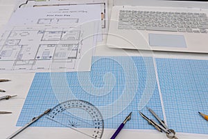 Paper for drafting and tools with laptop on desk