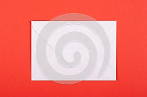 Paper envelope composition on red background. Flat lay