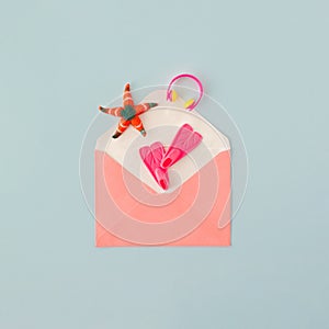 Paper envelope with fins, starfish and headphones on blue background. Summer pleasure or relax concept